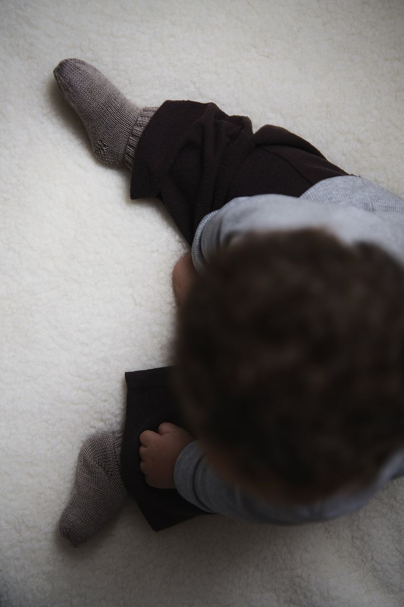 Baby draagt warme merinowollen slofjes van Kico Label voor zachte en ademende warmte