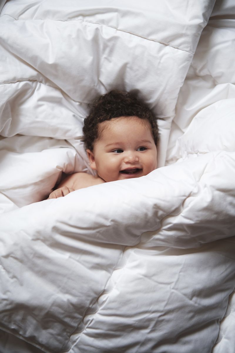 Kleintje slaapt vredig onder wollen 4‑seizoenen dekbed van KiCo Label in naturel kleur