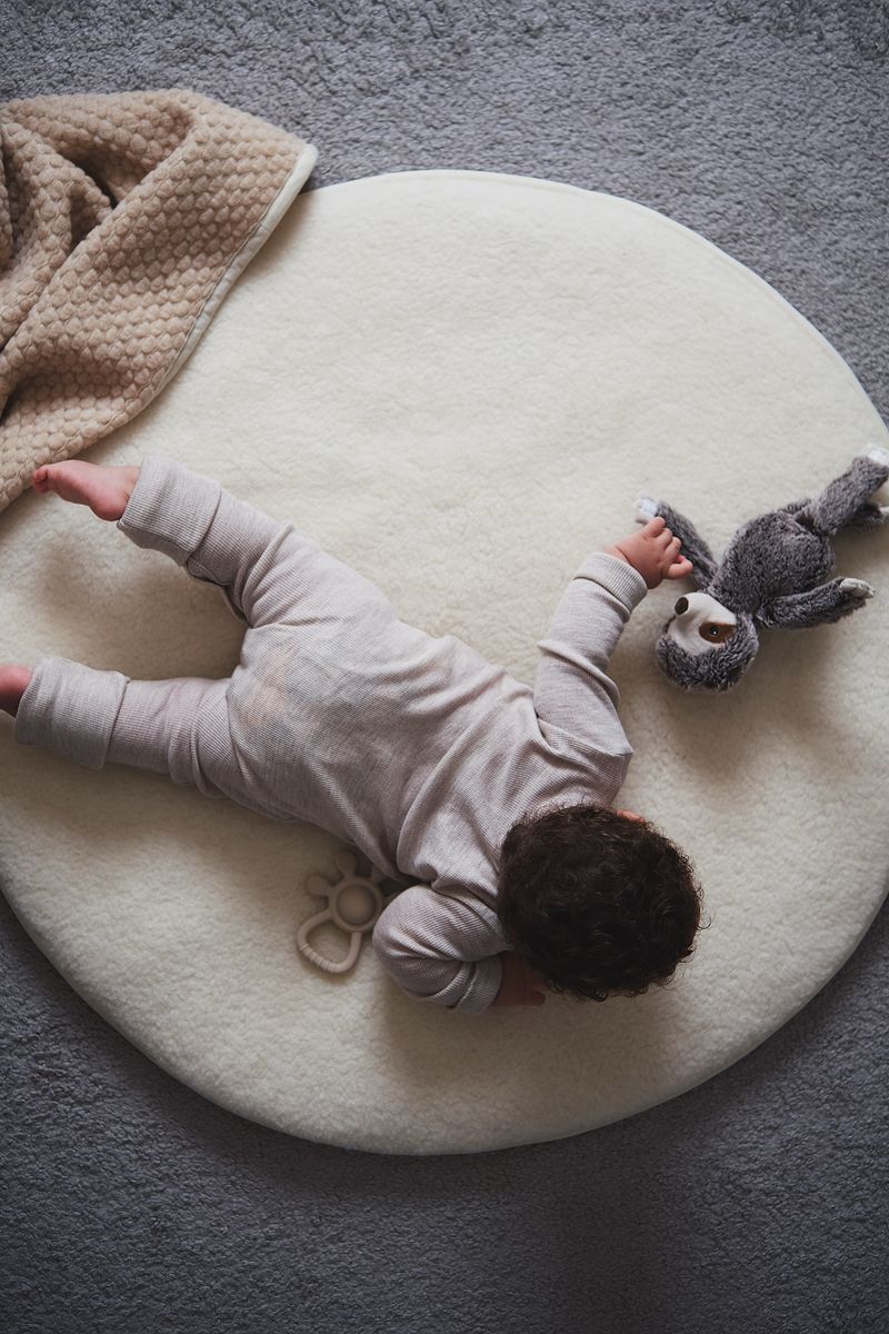 Rond boxkleed van 90 cm in naturel merinowol met baby erop, zacht en ademend - Kico Label