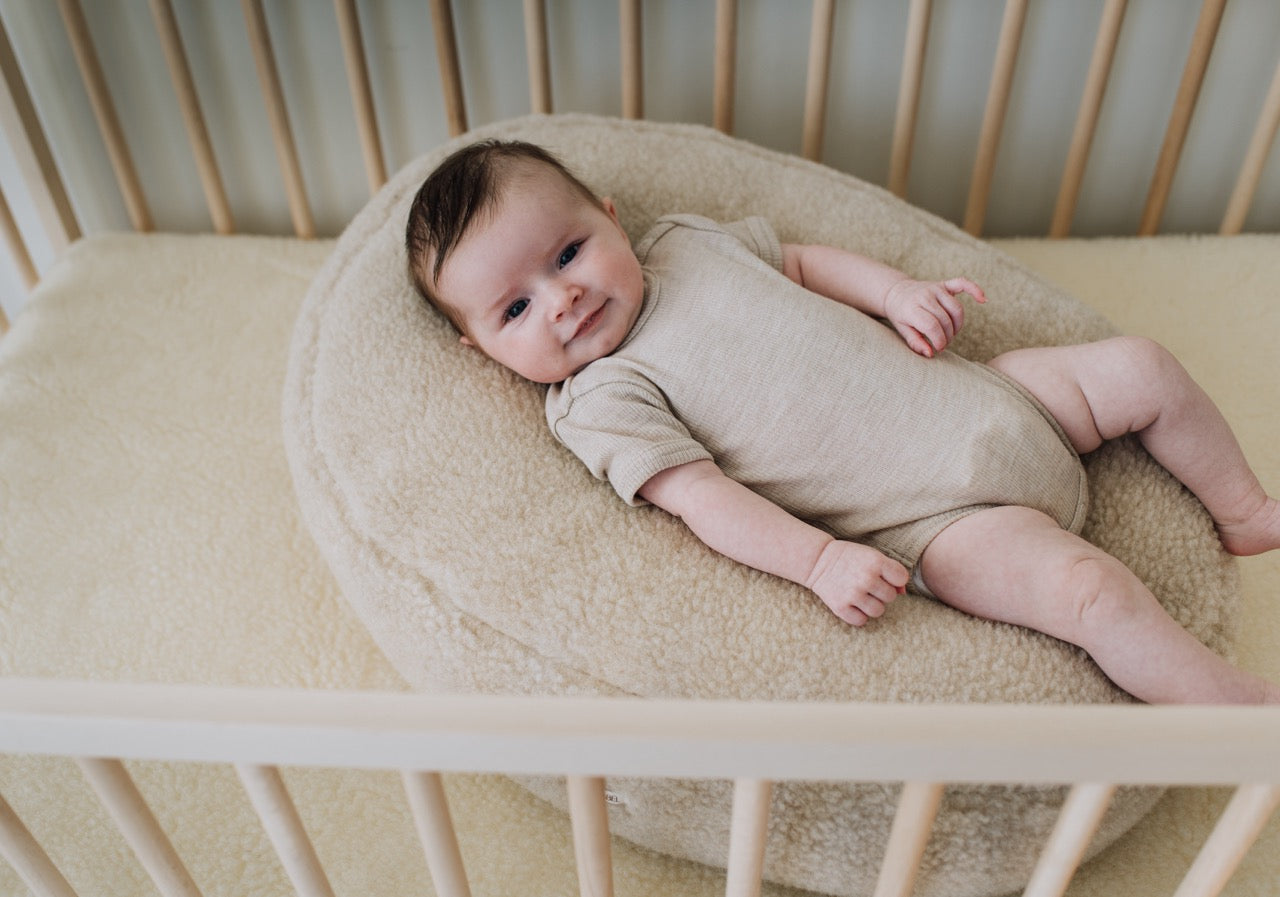 Baby ligt op voedingskussenhoes in de kleur beige