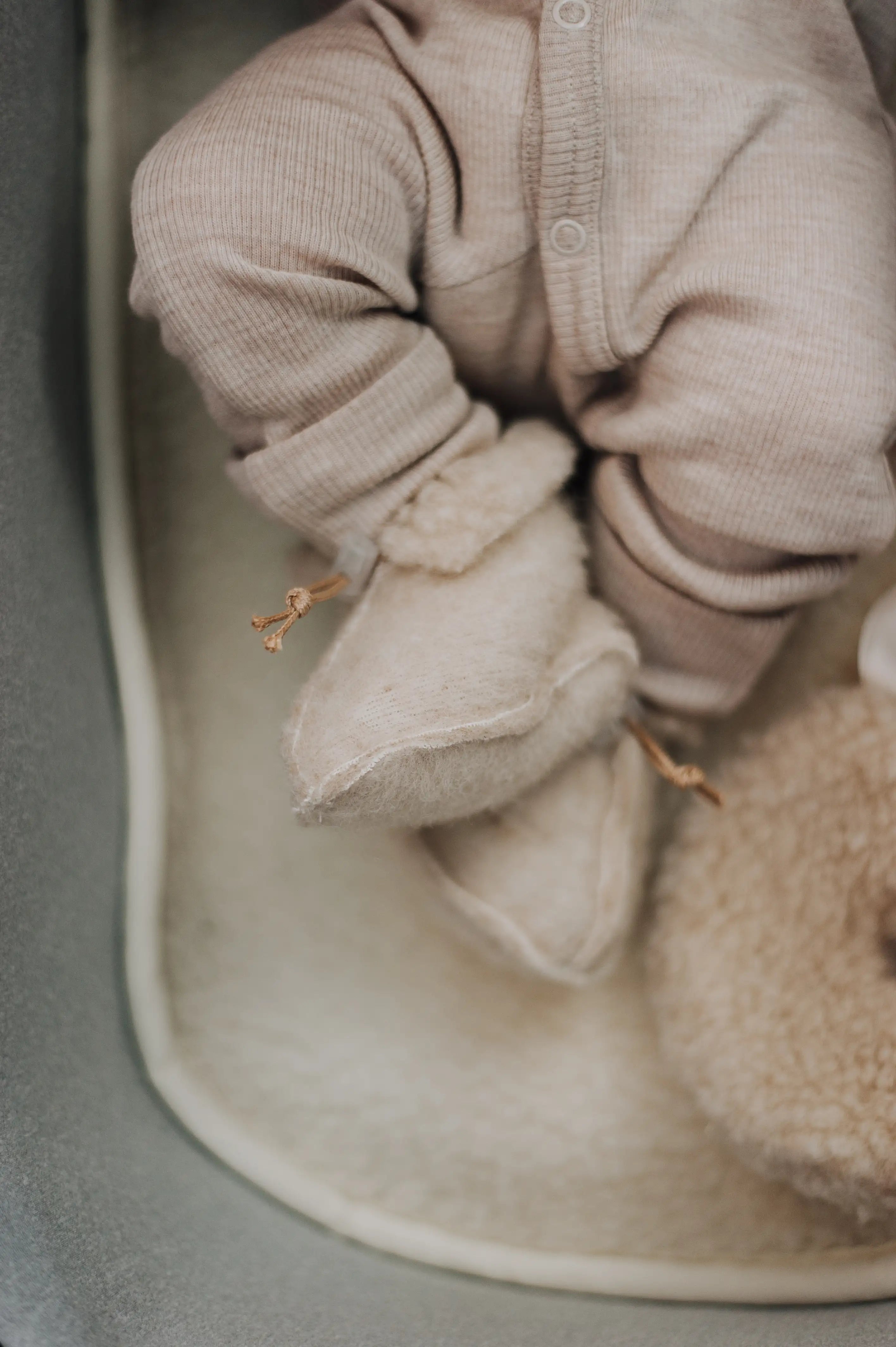 je ziet de onderste helft van die baby die ligt op een wollen onderlegger