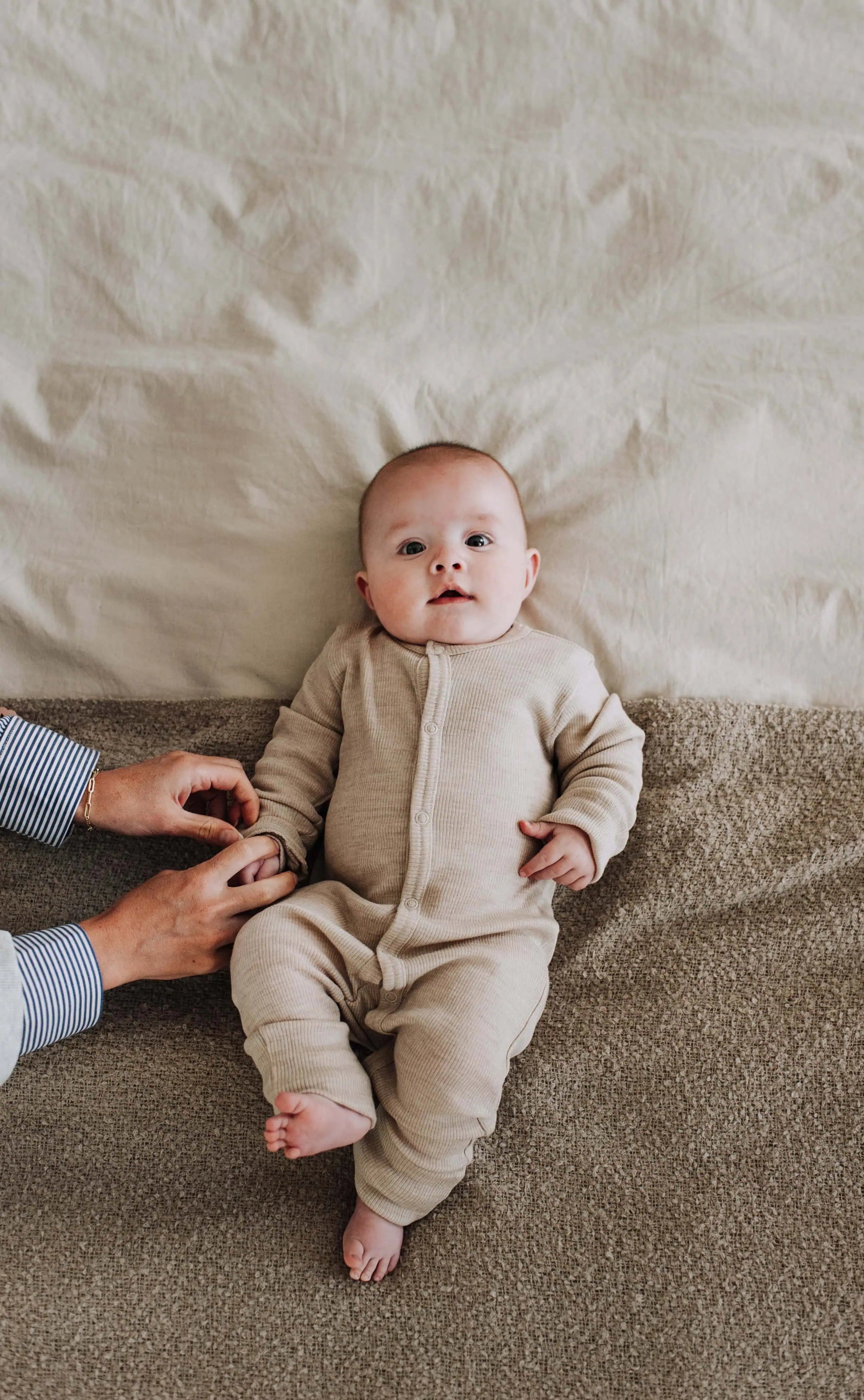 baby in wollen setje met knoopjes op de buik.
