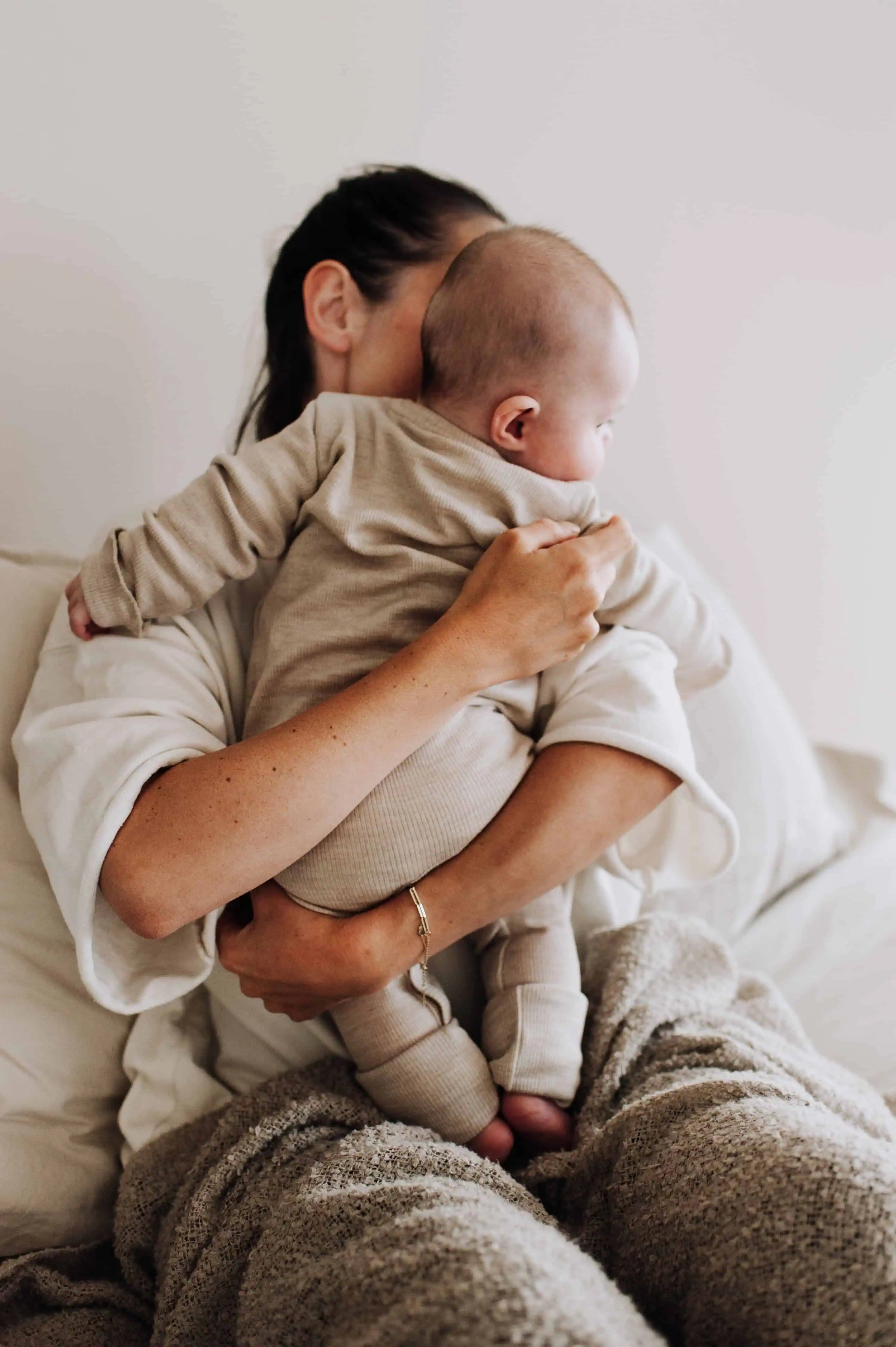 Foto van baby bij moeder op schoot van de achterkant geschoten.