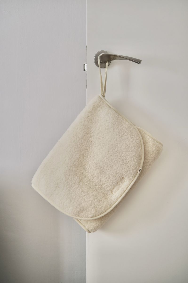 Merinowollen verschoonmat‑etui van Kico Label, netjes opgehangen, naturel