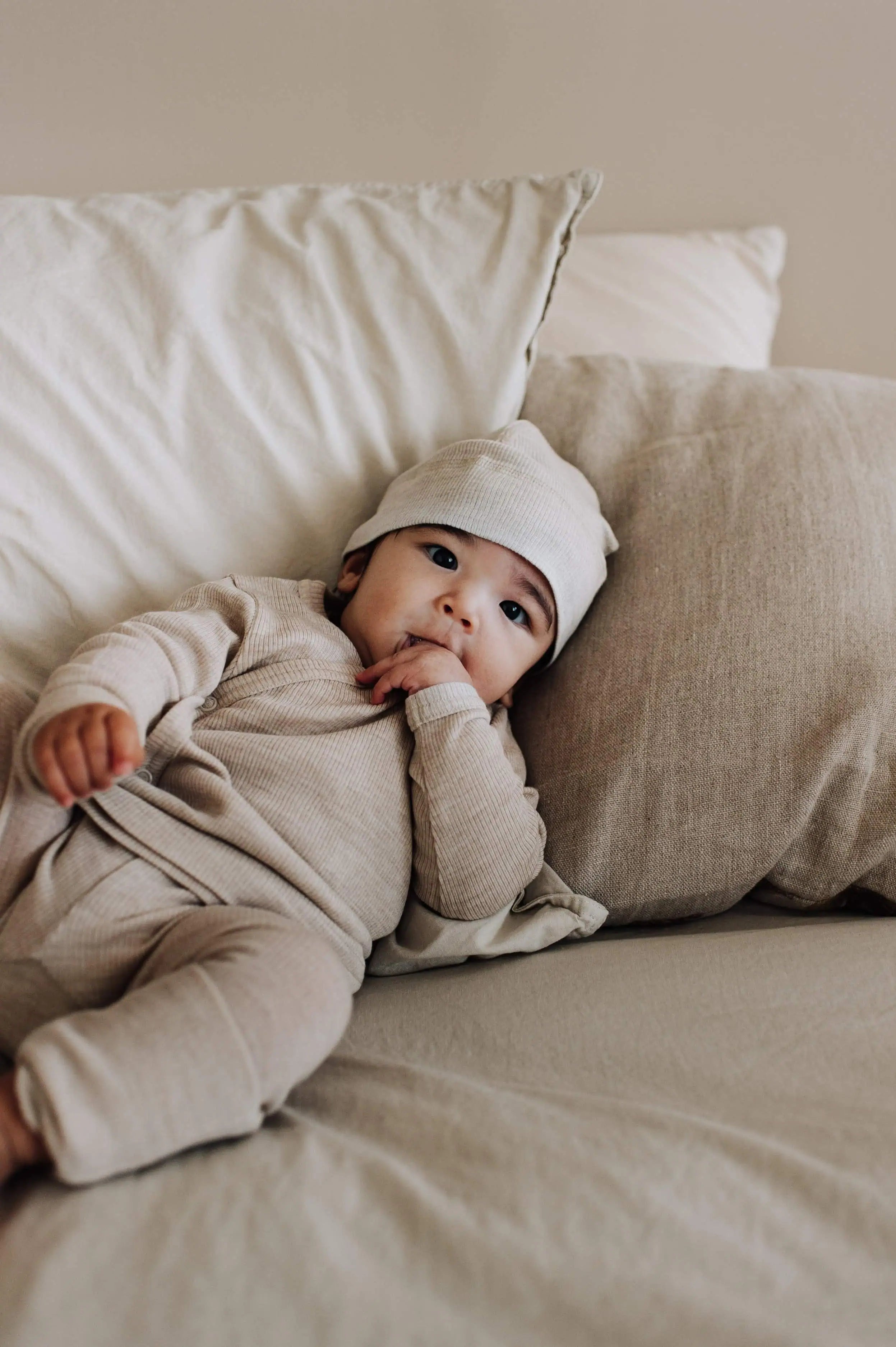 Baby in wollenoverslagset op bed